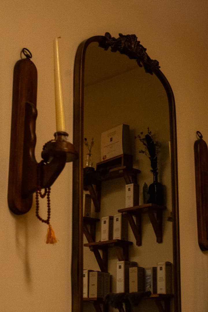 Antique gilt mirror with brass candle sconce and prayer beads