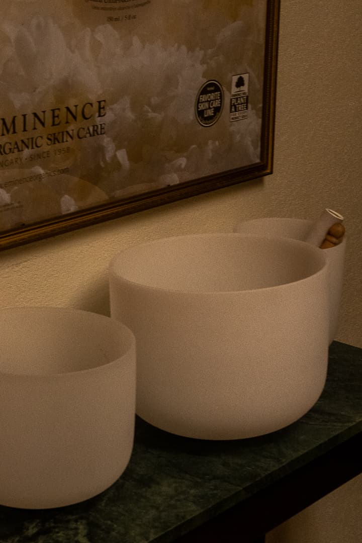 Crystal singing bowls on green marble, beneath the Eminence print